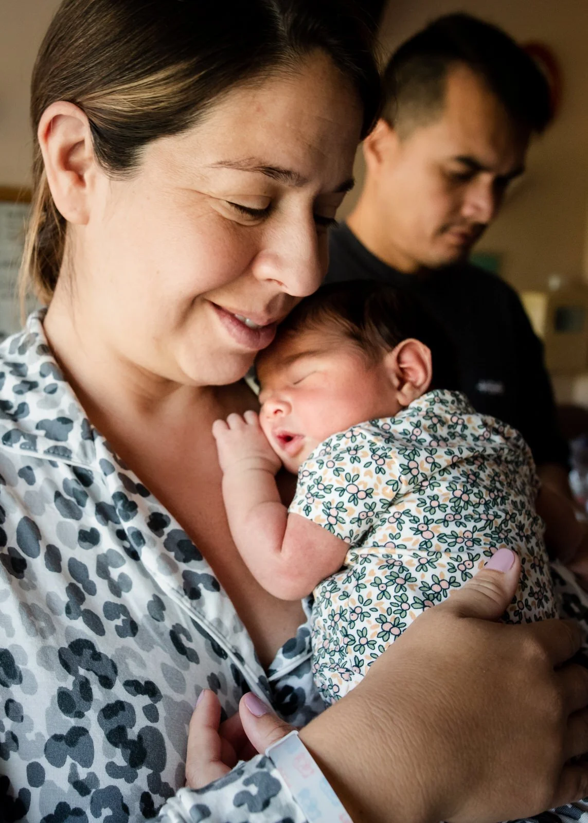 Newborn nursing and holding mother's finger